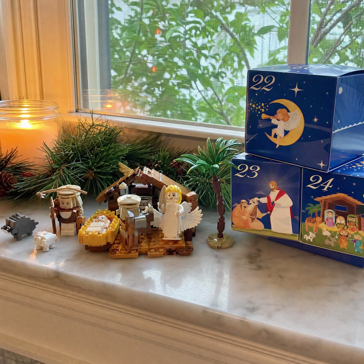 Partially completed nativity brick scene on a windowsill with candle